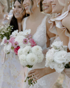 Close-up portrait of smiling bride holding pink and white wedding bouquet at backyard wedding