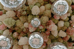 Extreme close-up of wedding floral installation with white pink and green hydrangeas packed with silver mirror disco balls